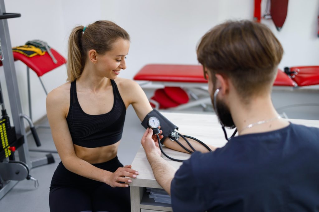 Female athlete undergoes an exercise tolerance test with a cardiologist