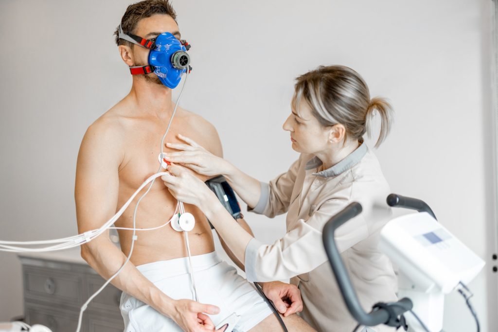 Nurse attaches electrodes to a man for cardio endurance test